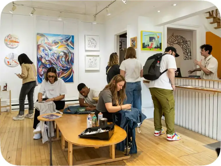 Des visiteurs entourés de toiles dans la galerie