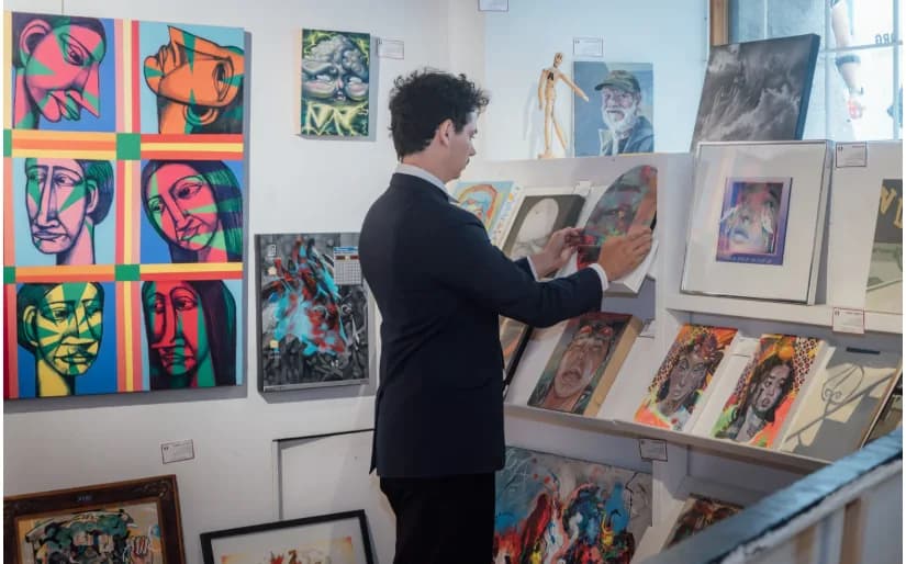 Un visiteur choisit une toile dans la galerie