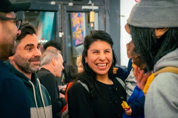 Volunteer in art gallery surrounded by colorful artwork