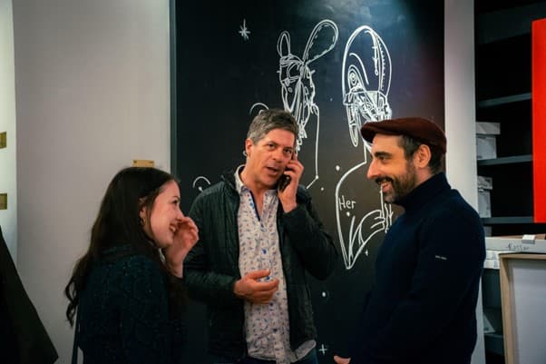 Volunteer in art gallery surrounded by colorful artwork