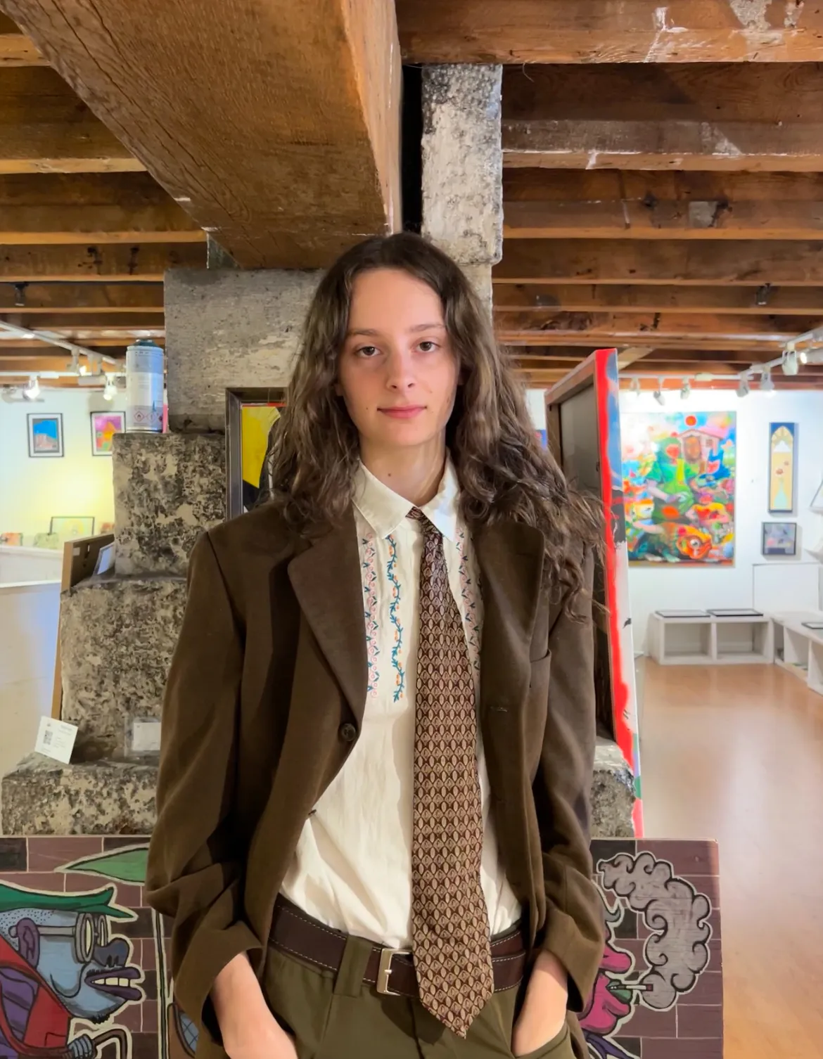 Volunteer in art gallery surrounded by colorful artwork