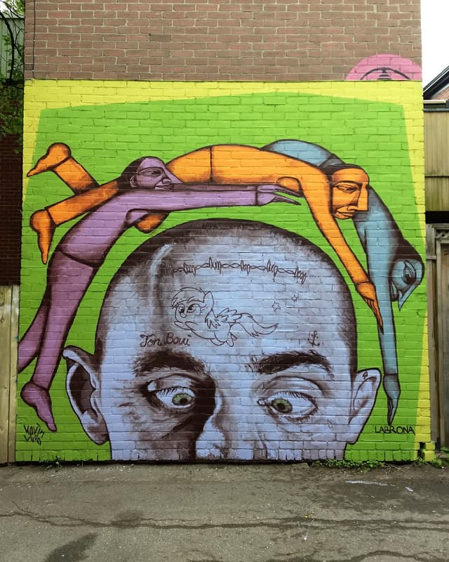 Kevin Ledo (central character) and Labrona (flying characters) in a Plateau alley